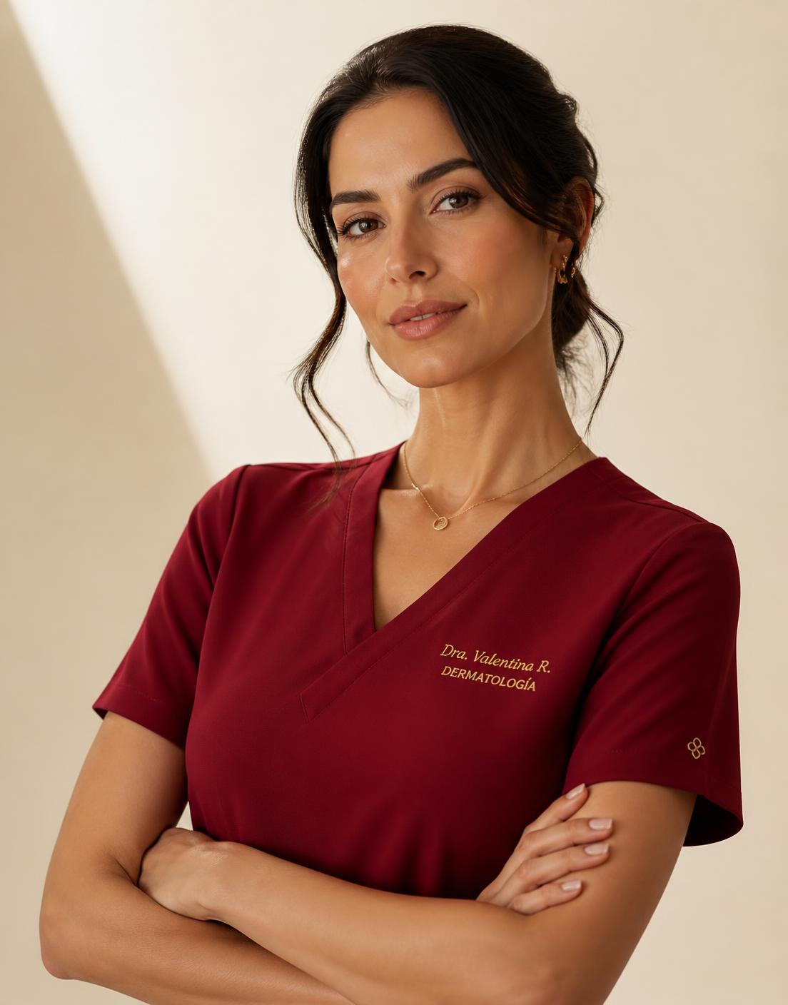 Portrait of a doctor in a crimson REDS scrub top with small gold chest embroidery